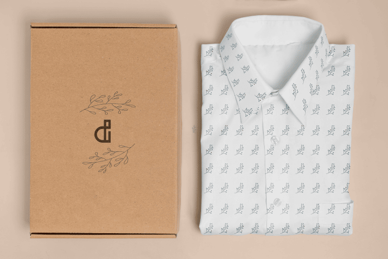 Cardboard box with Designerd logo "D" icon on the left with white ladies shirt folded on the right
